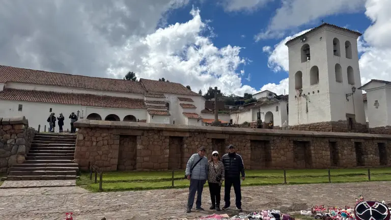 Colonial church of Chinchero on the Inca palace, with travellers in the square