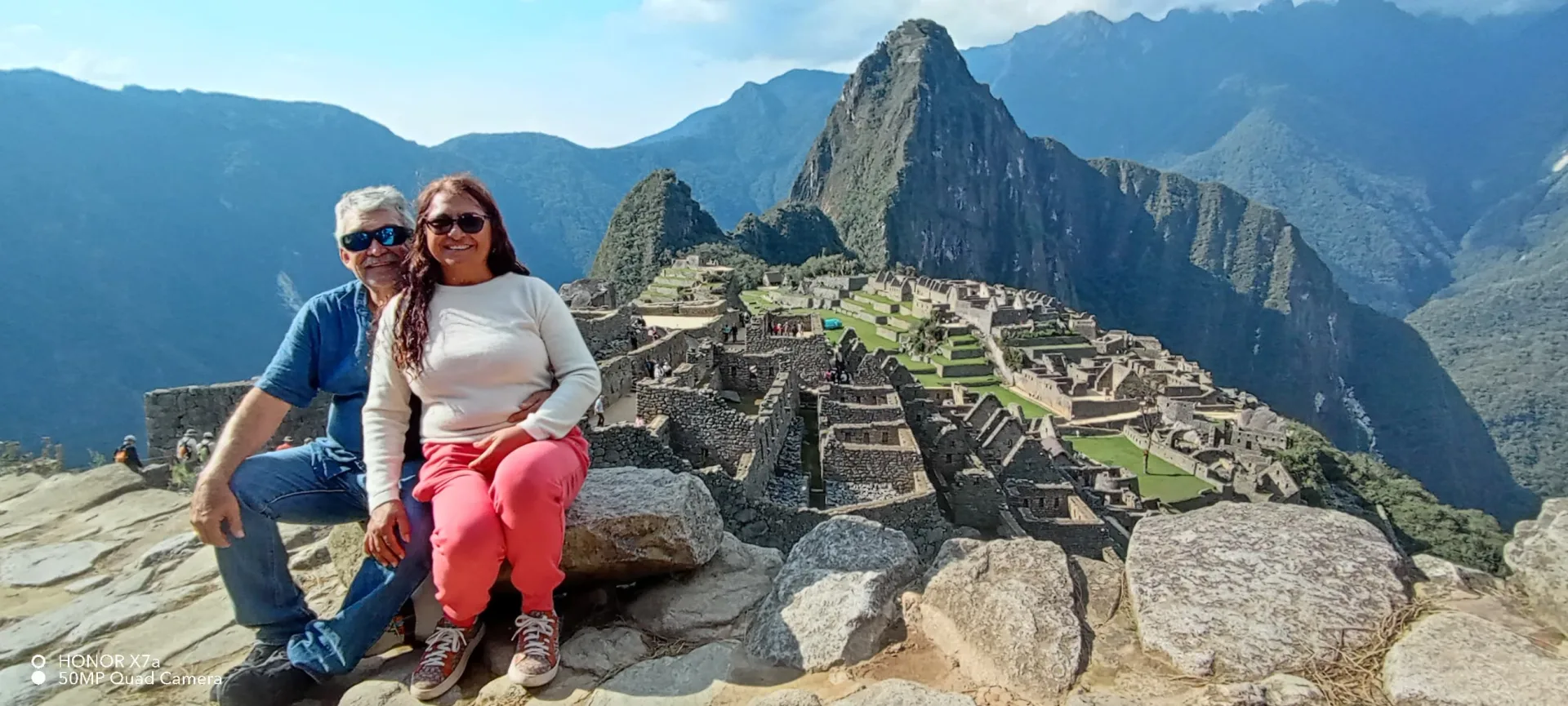 Couple at Machu Picchu with the citadel and Huayna Picchu behind