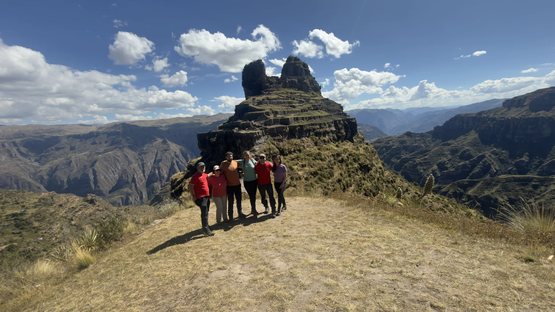 Grupo de viajeros frente a las torres de roca de Waqrapukara
