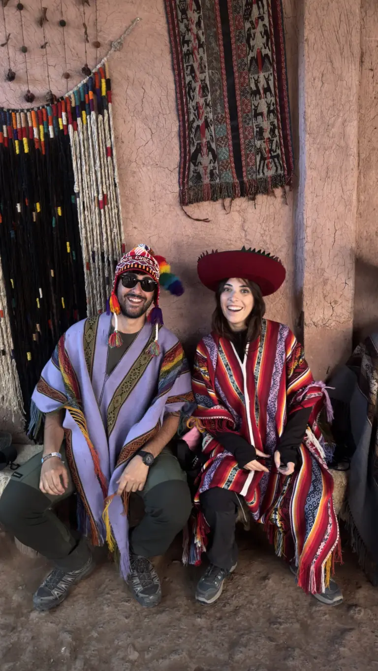 Couple wearing traditional ponchos at a textile centre in Chinchero