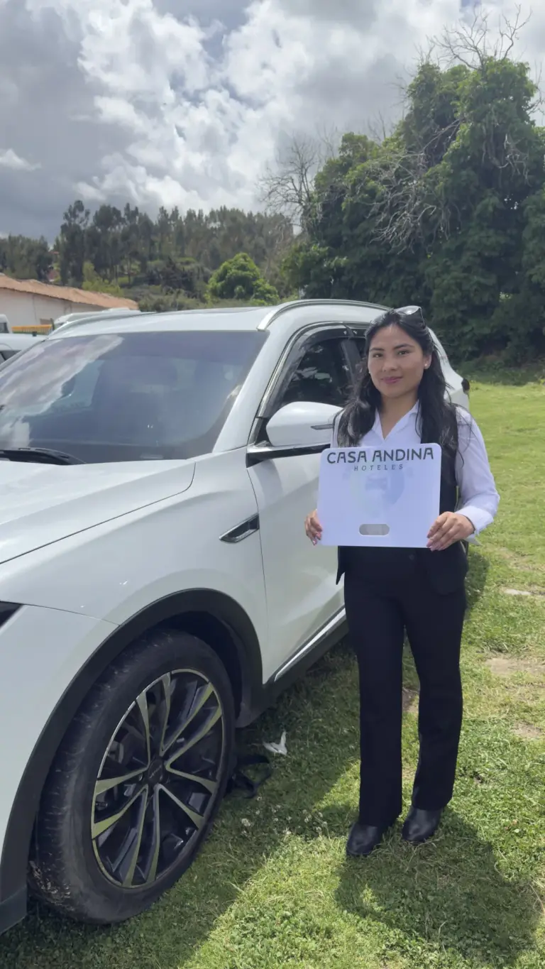 Andean Magic Travel driver holding the pickup sign next to an SUV
